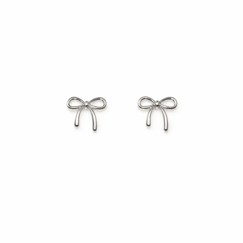 Set of silver bow-shaped nail charms on a white background