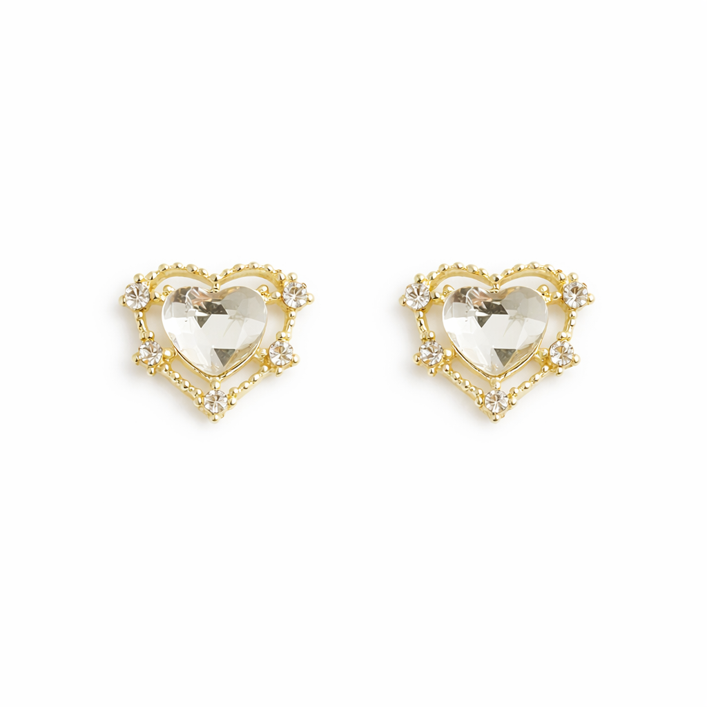 Gold heart-shaped nail charms with clear gemstones on a white background