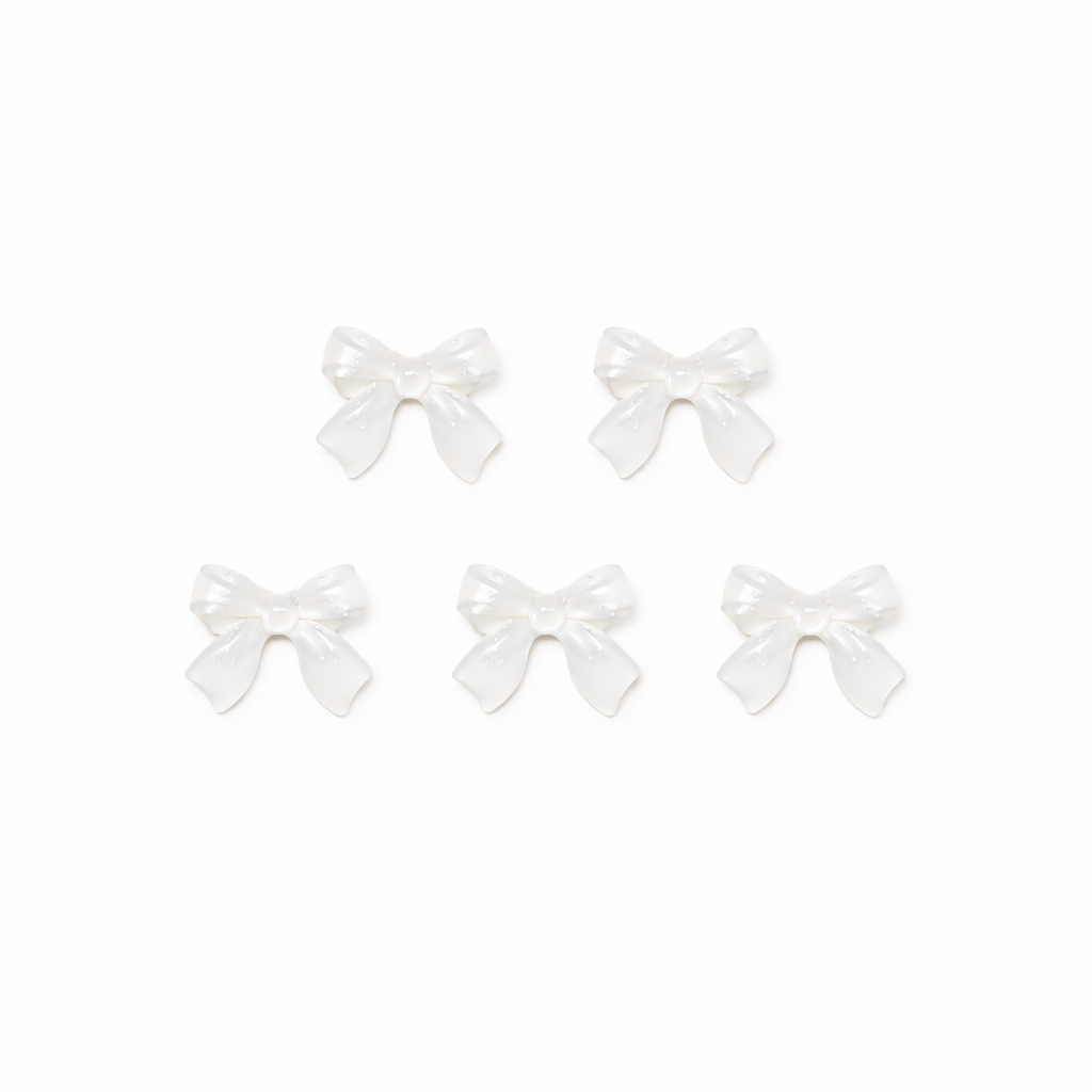 Set of five white bow-shaped nail charms on a white background