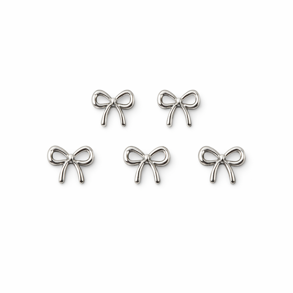 Set of silver bow-shaped nail charms on a white background